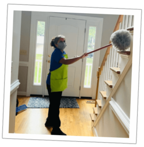 woman cleaning with an extended duster