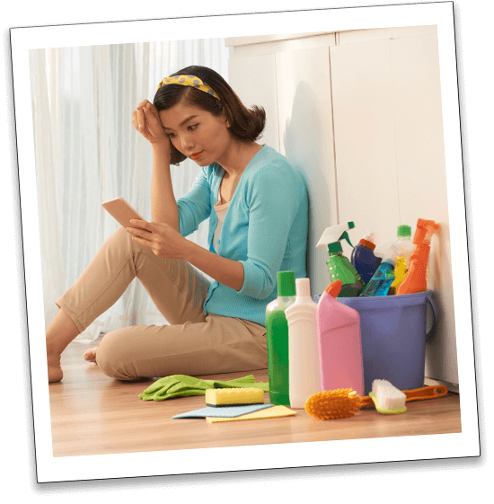 image of a housewife-sitting-kitchen-floor-cheking the carpediem cleaning blog, to see the list they are sharing how to clean the bathroom-using-smartphone